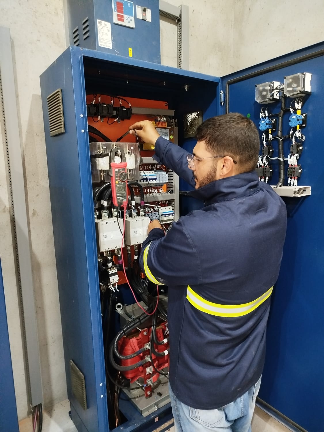 Profissional trabalhando em painel de automação industrial